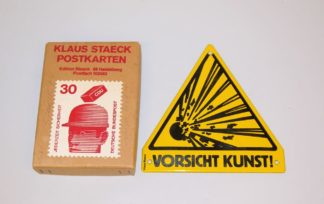 0471-Klaus Staeck, "Vorsicht Kunst", Emaille-Schild von 1984 sowie Postkartenkarton mit 50 Postkarten